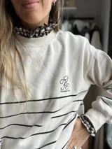 Cuellito y puños de tela con estampado de cuadros vichy en color negro y blanco, con diseño de volados en el borde.