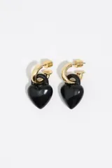 Pendientes de aro dorados con dije colgante en forma de corazón negro con acabado esmaltado y diseño tipo candado. Poseen cierre de presión.