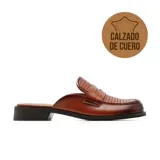 Zueco de cuero color marrón, con diseño destalonado, taco bajo y capellada con detalle trenzado.