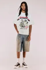 Remera de algodón color blanco crudo, corte oversized y manga corta. Presenta un estampado frontal grande con el logo de Metallica y la ilustración de Lady Justice, con el texto "AND JUSTICE FOR ALL" y "TOUR '83-'89".