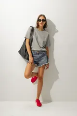 Short de jean de tiro medio con ruedo desflecado y cierre frontal con botón y cremallera.