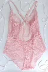 Body de encaje negro con escote profundo en V y espalda baja con breteles elásticos regulables cruzados.