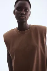 Musculosa de punto de algodón lavado color marrón, con cuello redondo acanalado y hombreras marcadas.