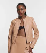 Campera básica de cuero sintético (PU) color marrón oscuro, con cuello redondo, cierre frontal y recortes decorativos. Cuenta con mangas largas y bolsillos con cierre.