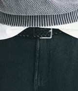 Cinturón de ancho mediano confeccionado en material sintético con textura trenzada y hebilla cuadrada metálica.