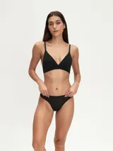 Bralette de diseño triangular confeccionado en tela suave, con breteles finos regulables y banda elástica en la base para mayor soporte.