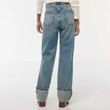 Pantalón de jean celeste, de corte recto y tiro alto, con lavado gastado y dobladillo ancho.