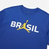 Remera Air Jordan de manga corta y cuello redondo, color azul, con diseño gráfico estampado en el frente que dice "BRASIL" integrando el logo Jumpman en color amarillo en lugar de la letra "A".