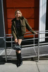 Falda pantalón de tiro medio en color gris oscuro con textura sutil. Presenta un diseño de corte recto y minimalista, con un cinturón fino integrado que incluye una hebilla metálica central. Cuenta con cierre lateral oculto.