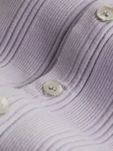 Cárdigan cropped Calvin Klein Jeans color lila de punto de algodón elástico con textura de canalé irregular, cuello en punta, manga larga, cierre de botones e insignia con el logo de Calvin Klein en el bajo.