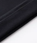 Buzo de corte holgado tipo ballon, color marrón oscuro, con cuello alto y cierre frontal parcial. Presenta mangas largas con puños elásticos y cordón ajustable en el ruedo.