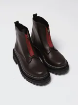 Botinetas de cuero negro con diseño combinado en gamuza y cuero texturizado. Presentan cierre frontal central, suela track dentada con costuras visibles en contraste y caña media.