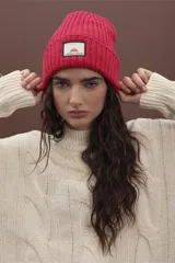 Gorro de punto fucsia con etiqueta de marca en el frente.