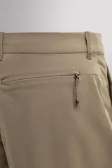 Pantalón técnico de corte regular fit en color marrón, confeccionado en tejido elástico y compacto. Cuenta con cintura ajustable con cordón interior, bolsillos frontales, bolsillo trasero con cierre oculto y bolsillo lateral con cierre en la pernera. El bajo es ajustable mediante botones a presión.