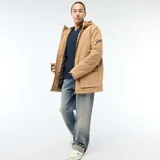 Parka ligera color beige con capucha ajustable, cierre frontal con cremallera y parche decorativo con texto en la manga.
