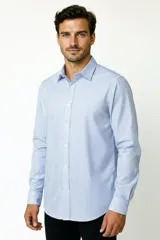 Camisa de algodón de manga larga con diseño de rayas verticales en tonos gris y blanco, cuello camisero clásico y cierre frontal con botones.