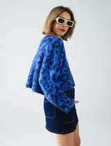 Buzo de lana con cuello redondo, manga larga amplia y corte crop. Presenta un estampado animal print en tonos de azul vibrante.