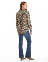 Camisa de manga larga con cuello camisero y cierre frontal de botones. Presenta un estampado abstracto en tonos azul marino y beige.