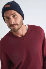 Sweater de punto color bordó con escote en V, de corte regular, con puños y dobladillo acanalados y logo bordado en el pecho.