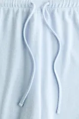 Pantalón de punto fino con corte relajado, piernas rectas y cintura elástica con cordón ajustable.