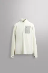 Camiseta de manga larga color crudo confeccionada en tejido técnico, ligero y elástico. Cuenta con cuello alto con cierre de cremallera, bolsillo frontal con cremallera y puños con cinta combinada a contraste.