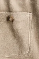 Pantalón de punto pesado color beige con acabado cepillado suave, de piernas rectas, cintura elástica y bolsillos delanteros tipo parche con botón.