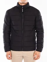 Campera acolchada negra, con cuello alto y cierre frontal de cremallera. Presenta costuras horizontales que crean un efecto acolchado y un parche con el logo de Calvin Klein en la manga izquierda.
