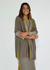 Saco azul de tejido de punto con rayas horizontales en tonos grises y detalles en rojo. Tiene corte holgado, mangas 3/4 y bolsillos laterales.