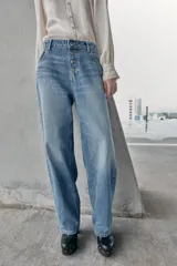 Jeans de tiro alto, color celeste claro con efecto desgastado y lavado. Modelo de corte holgado (loose baggy) con cierre frontal de botones metálicos y cinco bolsillos.