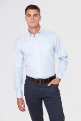 Camisa celeste lisa de vestir, con cuello clásico, manga larga, bolsillo en el pecho y corte regular.