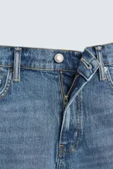 Bermuda de jean con corte regular fit, confeccionada en denim de algodón con elasticidad. Presenta diseño de cinco bolsillos, efecto lavado y cierre frontal con cremallera y botón.