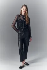 Pantalon de corte recto confeccionado en cuero ovino con acabado metalizado en color plata. Presenta cierre frontal con cremallera y bolsillos laterales.