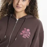 Campera con cierre frontal y capucha, color violeta, con diseño estampado de flores en el pecho y en la manga derecha. Posee bolsillos frontales tipo canguro y puños acanalados.