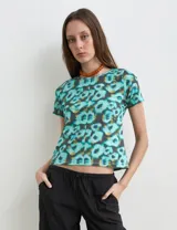 Remera de algodón con mangas cortas y cuello redondo, con estampado multicolor de efecto acuarela en tonos turquesa y negro.