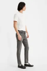 Jean skinny de hombre color gris oscuro, de tiro medio, con lavado desgastado y sin elasticidad.