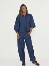 Camisa de denim azul con mangas abullonadas y cuello clásico.