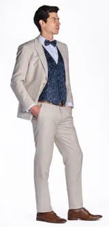 Ambo de tres piezas compuesto por saco, pantalón y chaleco. El saco y el pantalón son de color beige, mientras que el chaleco presenta un diseño estampado en tonos azul oscuro. Incluye camisa clara y moño a juego.