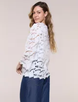 Chaqueta de encaje calado blanco, con escote en V, frente abierto y mangas 3/4 acampanadas con terminación festonada.
