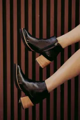 Botín de cuero color beige con puntera charolada, cierre lateral con cremallera y tacón ancho de madera.