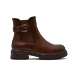 Bota corta estilo chelsea de cuero color marrón, con suela track dentada y detalle de tira con hebilla metálica en el tobillo.
