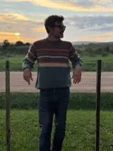 Sweater de punto con diseño de rayas horizontales en tonos tierra, verde y azul. Presenta cuello redondo, mangas largas y puños acanalados.