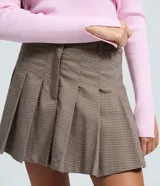 Short pollera de sastrería color marrón con estampa a cuadros, diseño plisado y cintura con pasadores. Combina la comodidad de un short con la estética de una minifalda.