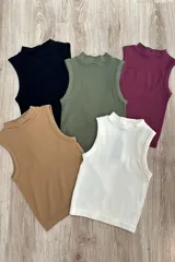 Musculosa color crema de punto acanalado con cuello alto y corte ajustado.