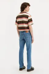 Jean de corte slim fit con tiro medio, confeccionado en denim de tono azul medio con acabado desgastado.