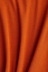 Remera de punto acanalado color naranja, de manga corta, cuello redondo y corte entallado.