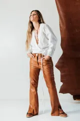 Pantalón de cuero de corte recto y tiro medio, con cierre frontal de botón y cremallera, acabado en tono azul petróleo.