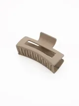 Pinza para el pelo de diseño rectangular con acabado mate en color beige.