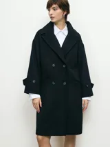 Tapado negro con doble botonadura, cuello solapa y mangas largas con botones decorativos en los puños.