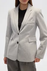 Blazer gris con cuello solapa, bolsillos frontales y cierre con dos botones.