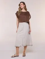 Falda midi evasé de mezcla de lino color beige, con abotonadura frontal completa, pretina elastizada en la espalda, pespuntes horizontales en contraste y terminación bordada en el ruedo. Incluye forro interior.